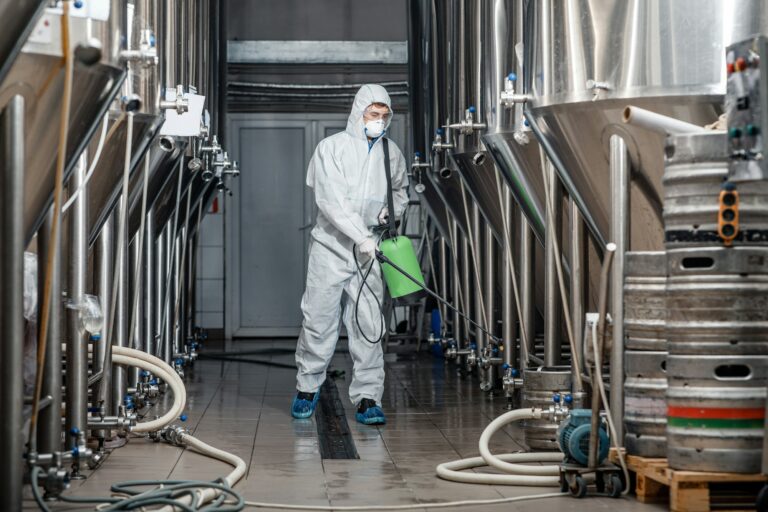 factory-cleaning-man-in-protective-suit-and-mask-disinfects-plant.jpg