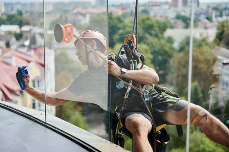 industrial-mountaineering-worker-cleaning-window-outside-building-.jpg